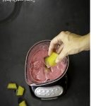 ginger turmeric ice cube with hand overhead view of berry smoothie
